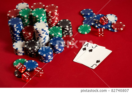 Two cards and chips on a red background. Big bet of game money. Cards - Ace and Jack. Your distribution at the table Two cards and chips on a red background. Big bet of game money. Cards - Ace and Jack. Your distribution at the table 82740807