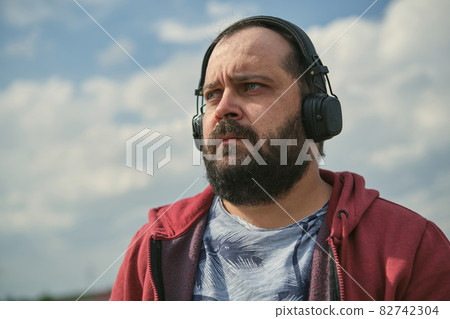 Middle aged man listening to music, close up 82742304
