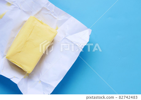 slice of a butter on a paper on table  82742483