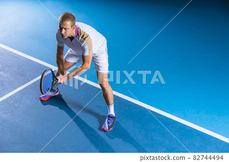 Full-length portrait of professional sportsman, tennis player during game isolated over gym background 82744494