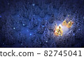 lightened christmas trees surrounded by snow-covered pine trees at night 82745041