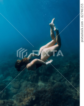 Woman freediver dive underwater in sea. Freediving and beautiful lady in ocean 82746155