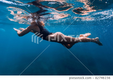 Sporty woman in bikini swimming in clear sea. Activity summer days in ocean 82746156