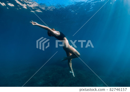 Woman freediver posing underwater in ocean. Free diving and beautiful lady Woman freediver posing underwater in ocean. Free diving and beautiful lady 82746157