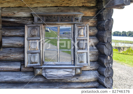 Platbands and shutters are decorated with traditional Russian northern carvings. House of the Oshevnev peasants from Zaonezh. Kizhi Island. Republic of Karelia. Russia 82746376