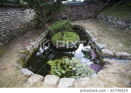 A small pond in a stone wall 82746629