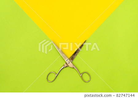 Colorful green and yellow background with metal scissors Colorful green and yellow background with metal scissors 82747144