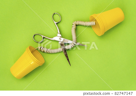 Plastic can phones on green background with the cord got cut off Plastic can phones on green background with the cord got cut off 82747147