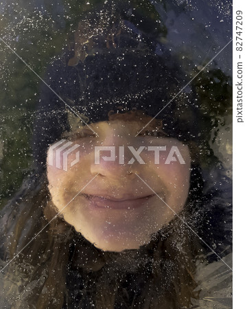 Girl hidden behind piece of ice floe in Choczewo, Pomerania, Poland 82747209