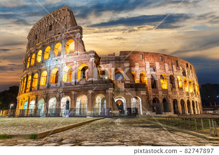 Illuminated Roman Coliseum under the clouds at sunrise, Italy 82747897