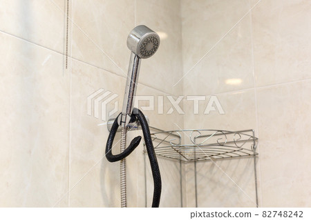 A poisonous snake in the bathroom wrapped around the shower 82748242