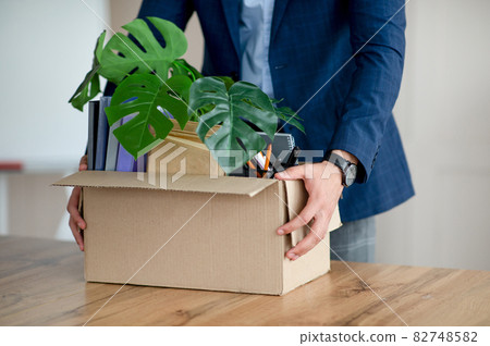 Young man with box of belongings quitting job, changing office, receiving promotion, having first day of new work 82748582