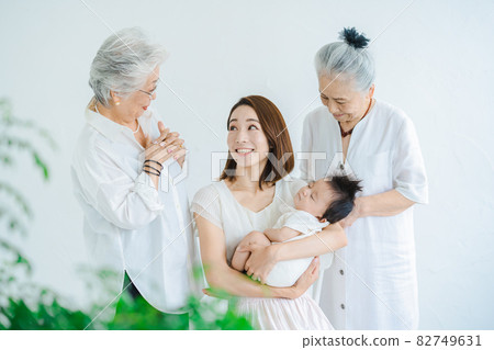 媽媽抱著一個嬰兒和兩個老年婦女 媽媽抱著一個嬰兒和兩個老年婦女 82749631