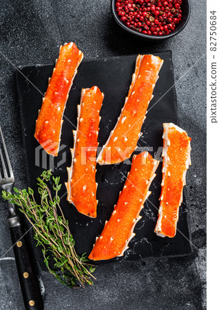 Crab legs Phalanx on a marble board with thyme. Black background. Top view 82750684
