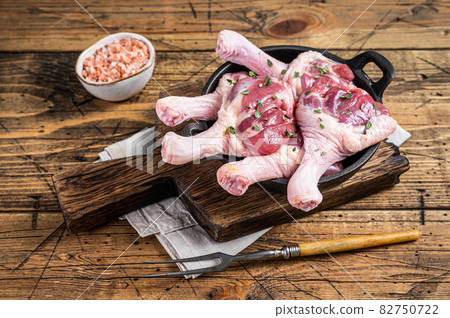 Raw Duck drumsticks in a pan with herbs. wooden background. Top view Raw Duck drumsticks in a pan with herbs. wooden background. Top view 82750722