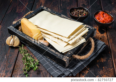 Ingredients for the preparation of Lasagna, Tomatoes, sauce, pasta. Dark wooden background. Top view Ingredients for the preparation of Lasagna, Tomatoes, sauce, pasta. Dark wooden background. Top view 82750727