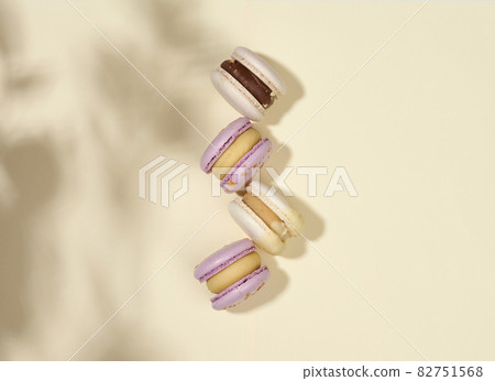 baked macarons with different flavors on a beige background, top view baked macarons with different flavors on a beige background, top view 82751568