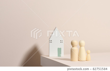 wooden family figurines, model house on a beige background. Real estate purchase, rental concept. Moving to new apartments 82751584
