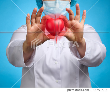 doctor in a white medical coat holding a red heart. Cardiovascular disease concept, early diagnosis. Blue background 82751596