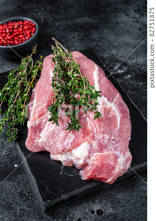 Raw pork shoulder meat cut on a marble board. Black background. Top view 82751875