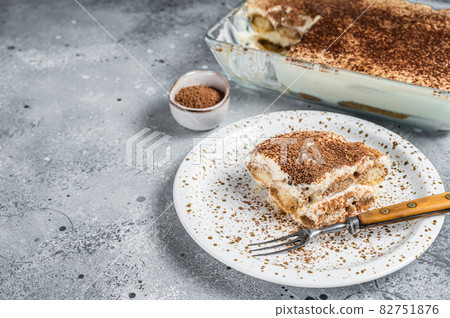 Tiramisu Italian dessert topped with cocoa on a plate. Gray background. Top view. Copy space 82751876