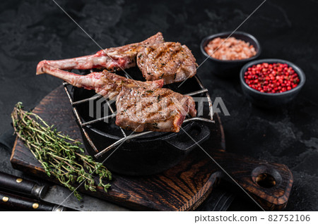 Grilled lamb mutton meat chops steaks on a grill. Black background. Top view Grilled lamb mutton meat chops steaks on a grill. Black background. Top view 82752106