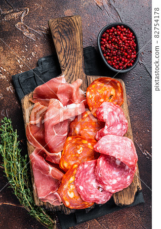 Spanish meat tapas - salami, jamon, choriso cured sausages. Dark background. Top view Spanish meat tapas - salami, jamon, choriso cured sausages. Dark background. Top view 82754178