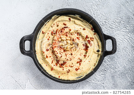 Hummus dip with chickpea in a bowl. White background. Top view 82754285