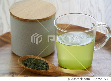 Green tea and tea leaves on a tray 82754977