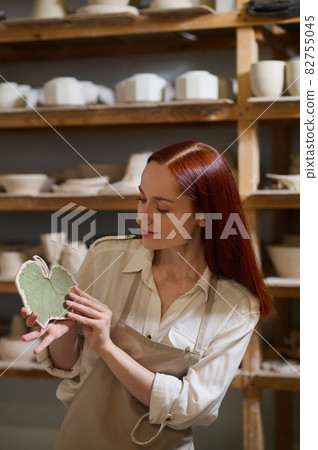 A young long-haired female potter in her workshop A young long-haired female potter in her workshop 82755045