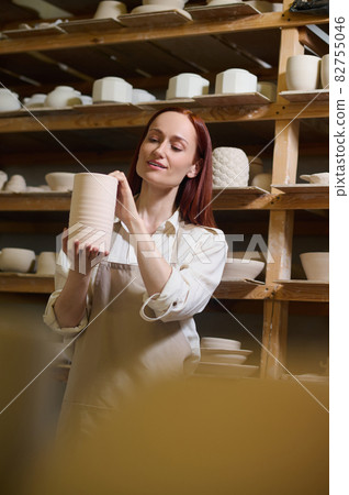 A young long-haired female potter in her workshop A young long-haired female potter in her workshop 82755046