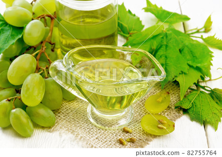Oil grape in gravy boat on white board 82755764