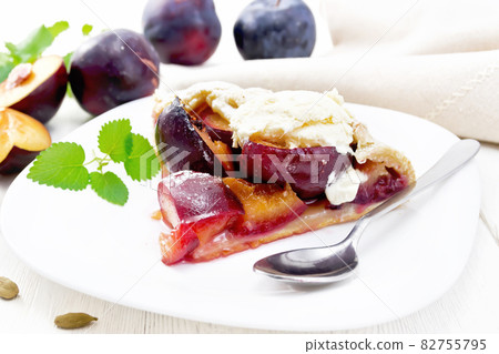 Galeta with plums in plate on white wooden board Galeta with plums in plate on white wooden board 82755795