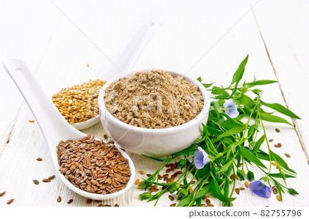 Flour linen in bowl with seeds on light wooden board Flour linen in bowl with seeds on light wooden board 82755796