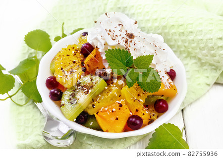 Salad fruit with cranberries in bowl on light board 82755936