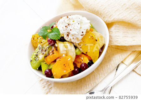 Salad fruit with cranberries and cream in bowl on light board Salad fruit with cranberries and cream in bowl on light board 82755939
