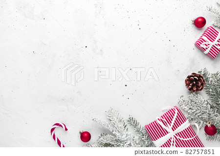 Christmas, New Year gray concrete flat lay with red white present gift boxes top view. Gift ribbon and packaging paper. Christmas tree fir, cones, toys, candy stick lolly, Copy space text area Christmas, New Year gray concrete flat lay with red white present gift boxes top view. Gift ribbon and packaging paper. Christmas tree fir, cones, toys, candy stick lolly, Copy space text area 82757851