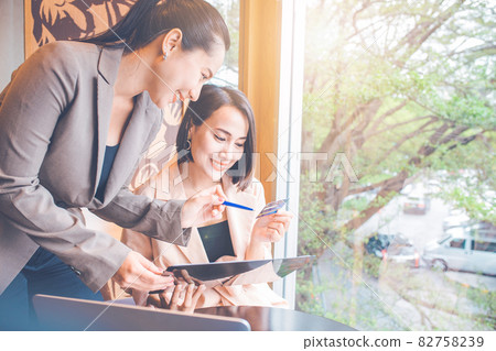 Female employee explaining credit card usage to customers. Female employee explaining credit card usage to customers. 82758239