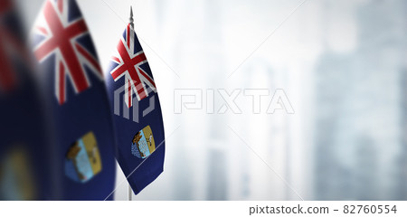 Small flags of Saint Helena on a blurry background of the city 82760554
