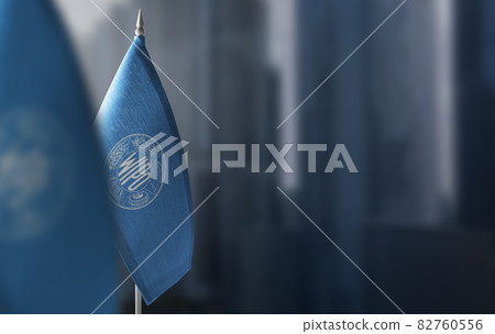 Small flags of International Intellectual Property Organization on a blurry background of the city 82760556
