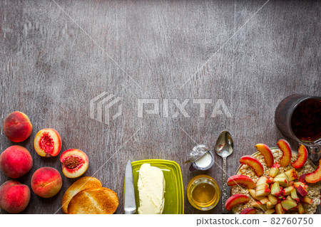 Oatmeal with peach, toast with butter and honey on a wooden table. The concept of a healthy breakfast Oatmeal with peach, toast with butter and honey on a wooden table. The concept of a healthy breakfast 82760750