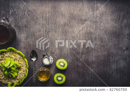 Healthy breakfast ingredients. Bowl of oat granola, fresh fruit and honey. Top view, copy space. Toned 82760789