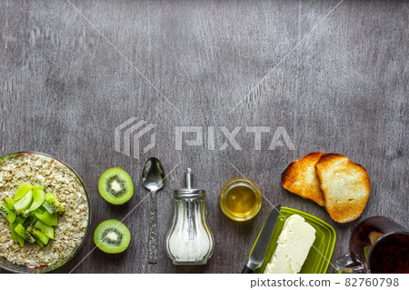 Oatmeal with kiwi, toast with butter and honey on a wooden table. The concept of a healthy breakfast Oatmeal with kiwi, toast with butter and honey on a wooden table. The concept of a healthy breakfast 82760798