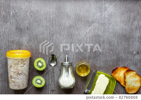 Oatmeal with kiwi, toast with butter and honey on a wooden table Oatmeal with kiwi, toast with butter and honey on a wooden table 82760808