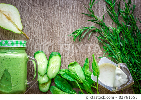 Healthy green smoothie with spinach in a mug against on wooden background Healthy green smoothie with spinach in a mug against on wooden background 82761553