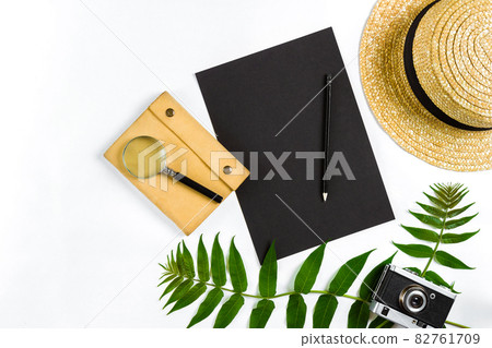 Straw hat with green leaves and old camera on white background, Summer background. Top view 82761709