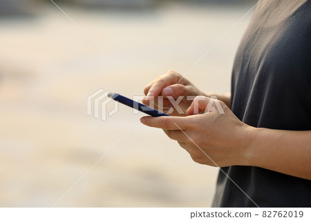 Asian woman using smartphone outdoors Asian woman using smartphone outdoors 82762019