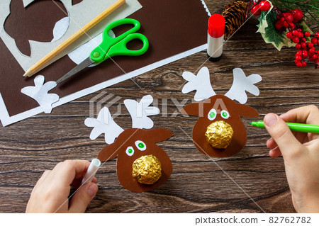 Instruction step 10. Funny Gift with candy Christmas deer on a wooden table. Handmade. Children's creativity project, crafts, crafts for kids. 82762782