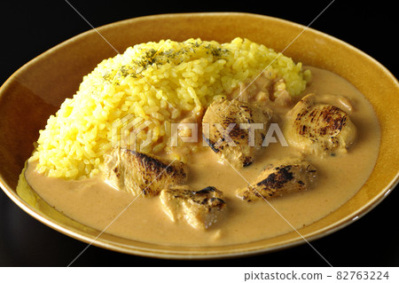 Tandoori chicken butter curry with chicken rumbling on a black background Tandoori chicken butter curry with chicken rumbling on a black background 82763224