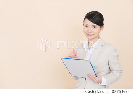 Woman in suit taking notes Woman in suit taking notes 82763654